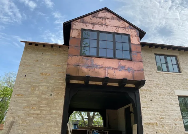 Copper metal panel facade on a stone building for Skylight Installation in Kewanee
